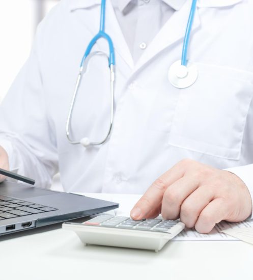 doctor-working-with-medical-statistics-financial-reports-doctor-counts-calculator-enters-data-into-laptop-male-doctor-using-laptop-calculator-office